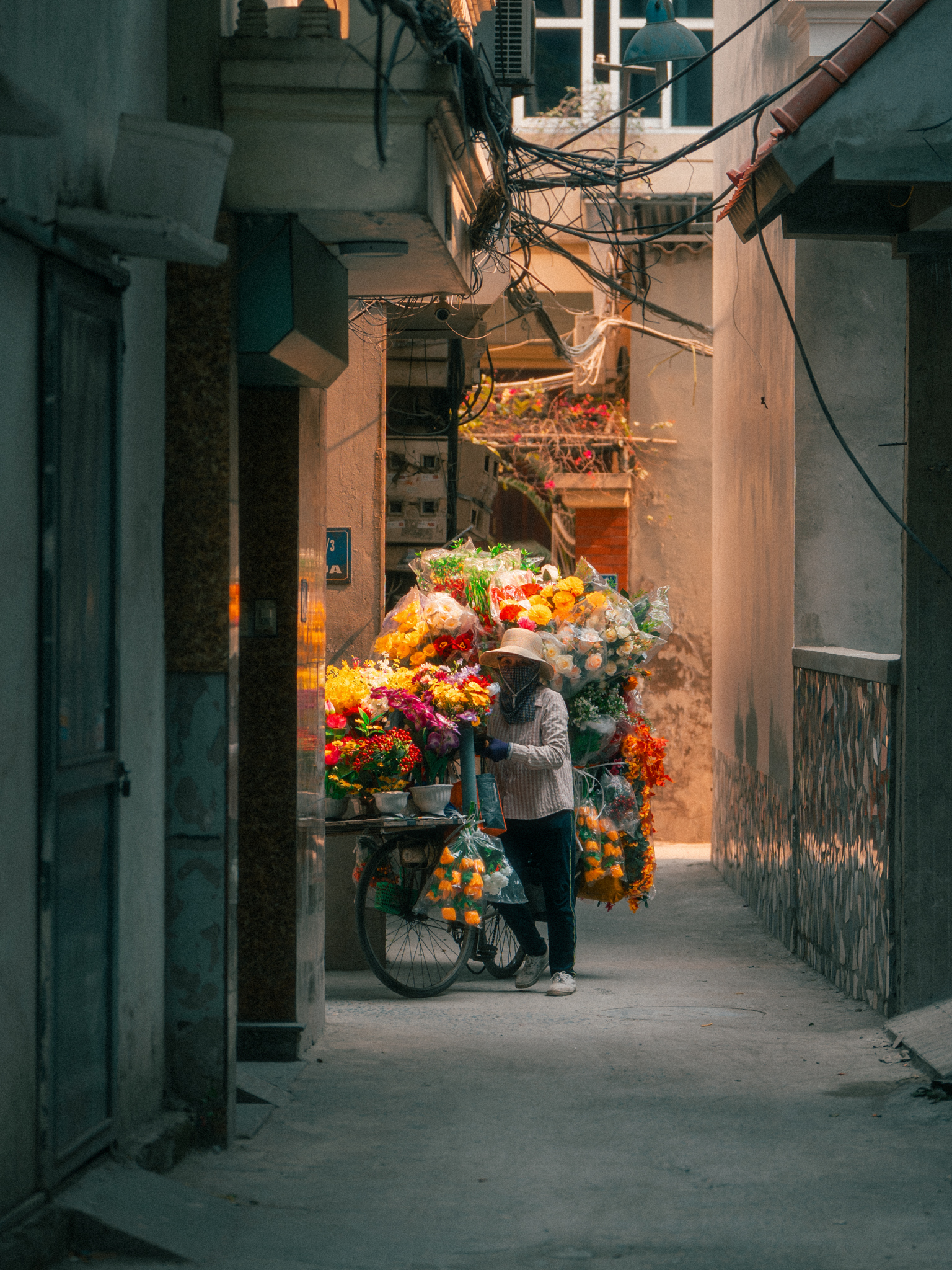 A flower seller navigates a narrow alley in Hanoi, Vietnam — one of the cities Kostromskikh says most changed how he shoots. © Andrei Kostromskikh / Kosnio