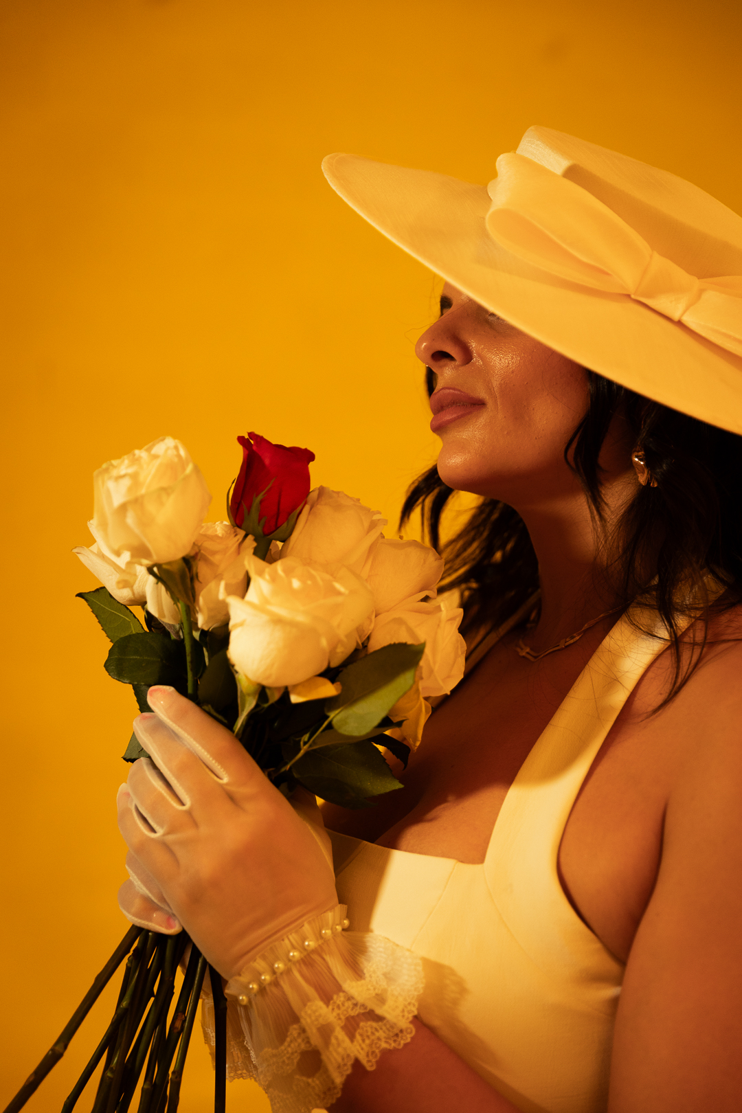 Soleil in a yellow studio holding roses.