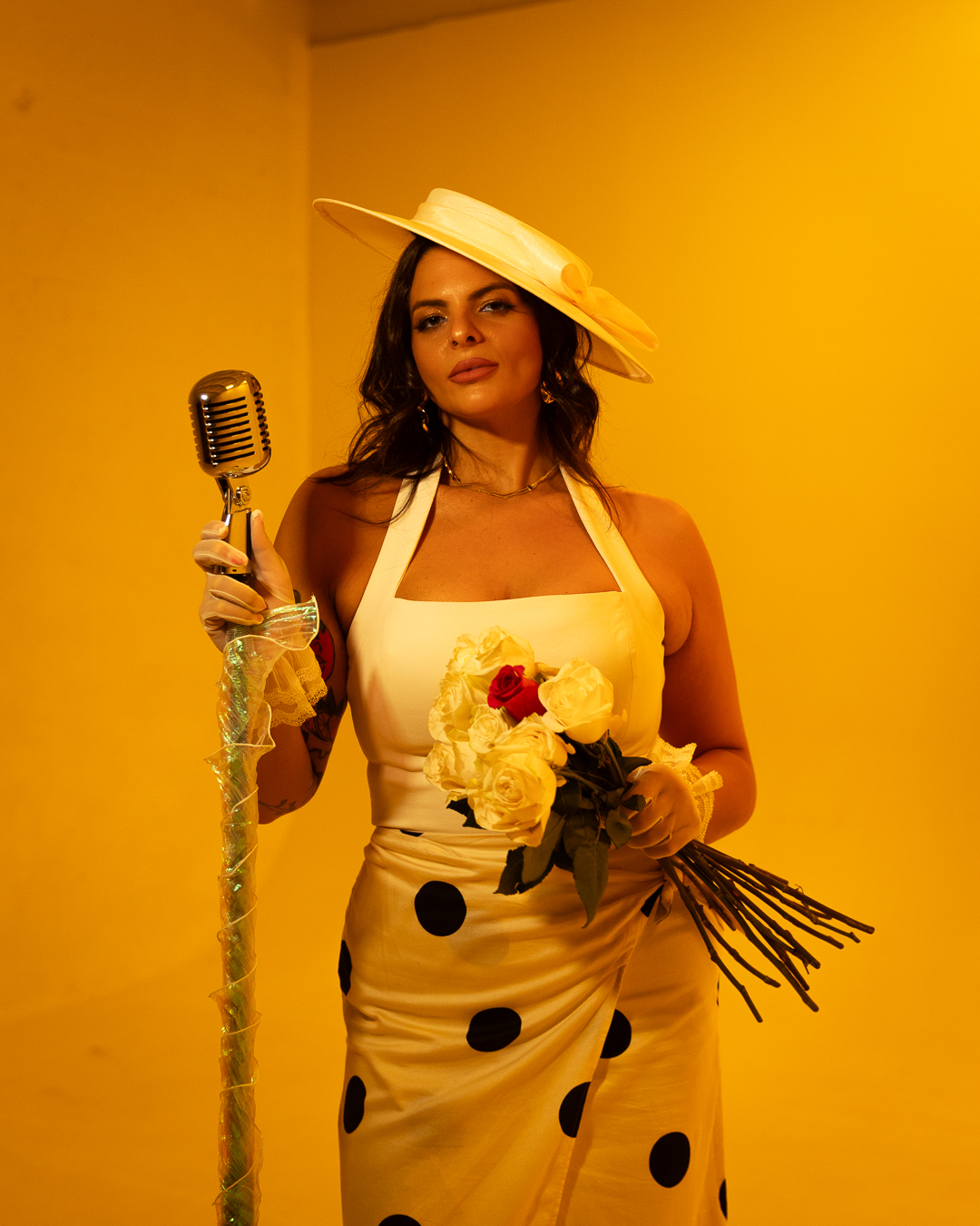 Soleil in a yellow studio holding roses.